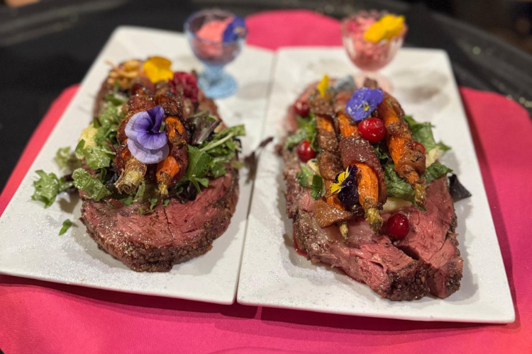 Two steaks plated side by side with colorful accoutrements