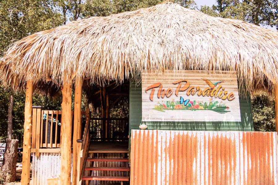 Well lit rustic rv with straw roof over bespoke patio