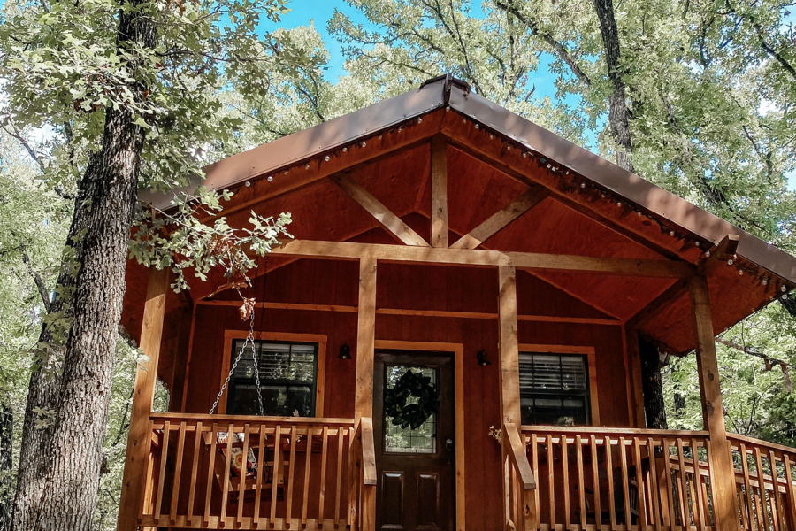 Wooden rustic cabin in the woods with a nice deck and metal roof